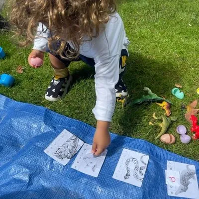 School-age child matching Spanish picture cards outdoors