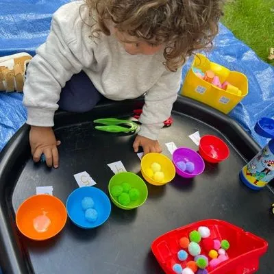 Child exploring a sensory tray during a private Spanish session at home